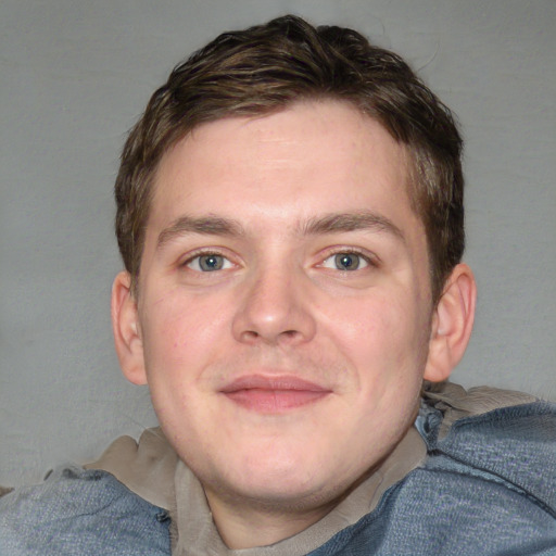 Joyful white young-adult male with short  brown hair and blue eyes