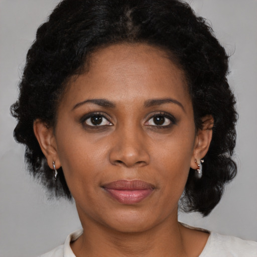 Joyful black adult female with medium  brown hair and brown eyes