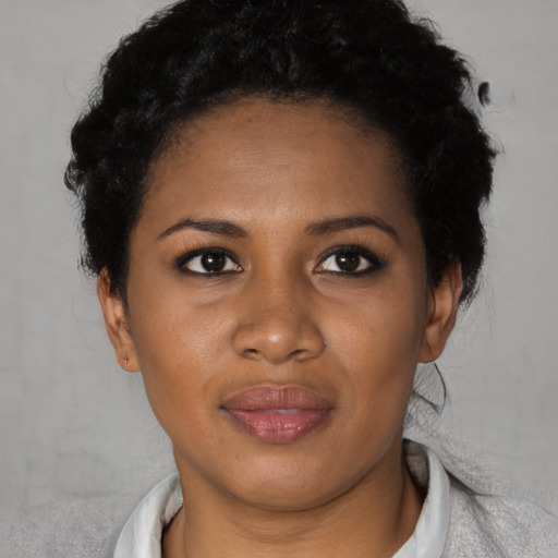 Joyful black young-adult female with short  black hair and brown eyes