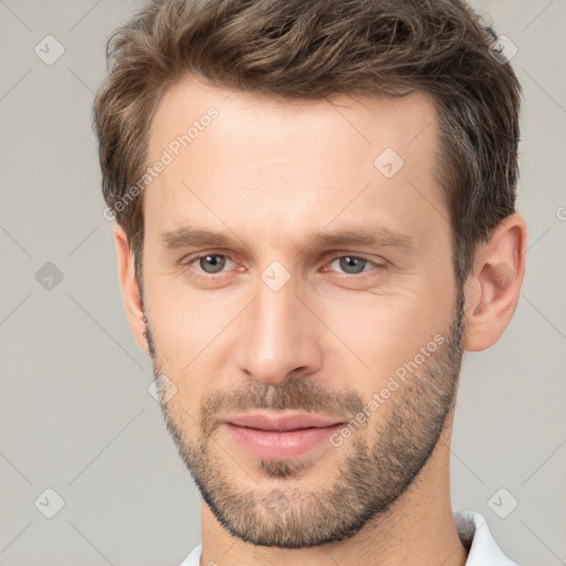 Joyful white young-adult male with short  brown hair and brown eyes