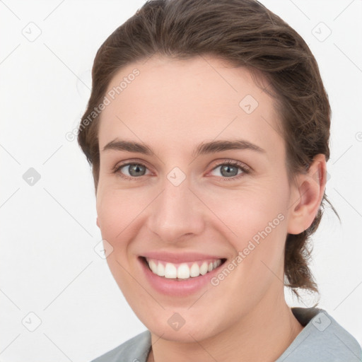 Joyful white young-adult female with medium  brown hair and grey eyes