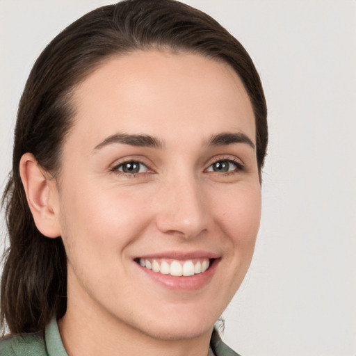 Joyful white young-adult female with medium  brown hair and grey eyes