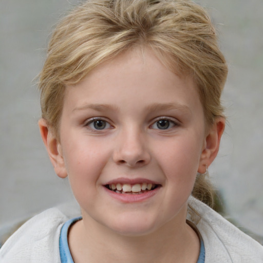 Joyful white child female with short  blond hair and blue eyes