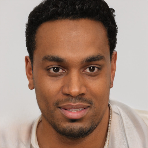 Joyful black young-adult male with short  brown hair and brown eyes