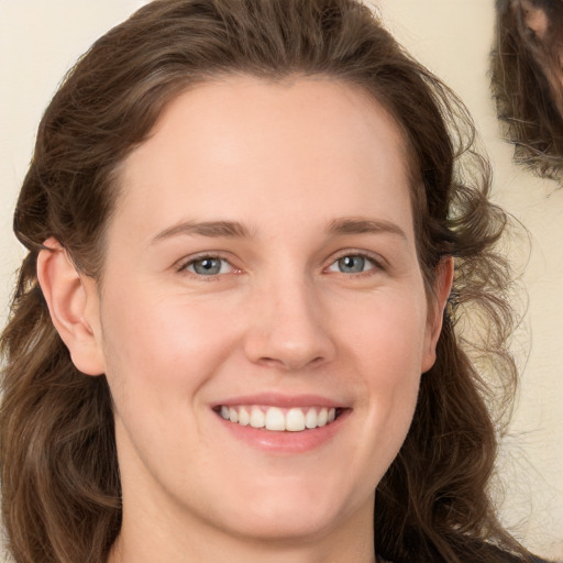 Joyful white young-adult female with medium  brown hair and grey eyes