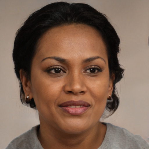 Joyful black adult female with medium  brown hair and brown eyes