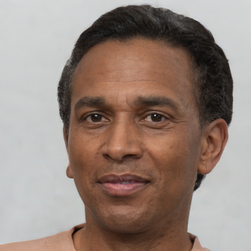 Joyful black adult male with short  black hair and brown eyes