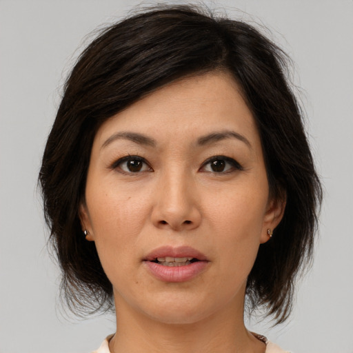 Joyful asian adult female with medium  brown hair and brown eyes