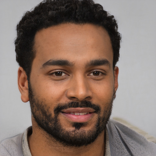 Joyful black young-adult male with short  black hair and brown eyes