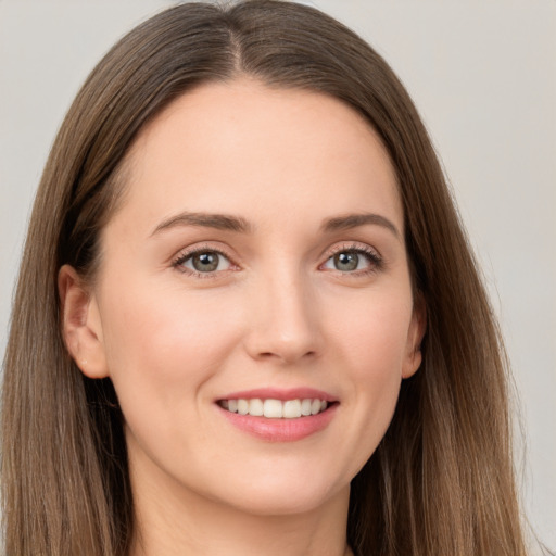 Joyful white young-adult female with long  brown hair and grey eyes