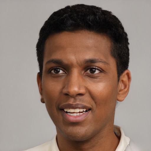 Joyful black adult male with short  black hair and brown eyes