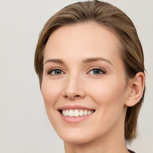 Joyful white young-adult female with long  brown hair and green eyes