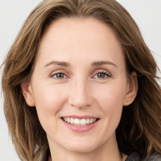 Joyful white young-adult female with long  brown hair and grey eyes