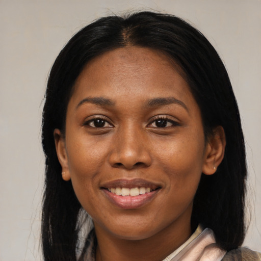 Joyful black adult female with long  black hair and brown eyes
