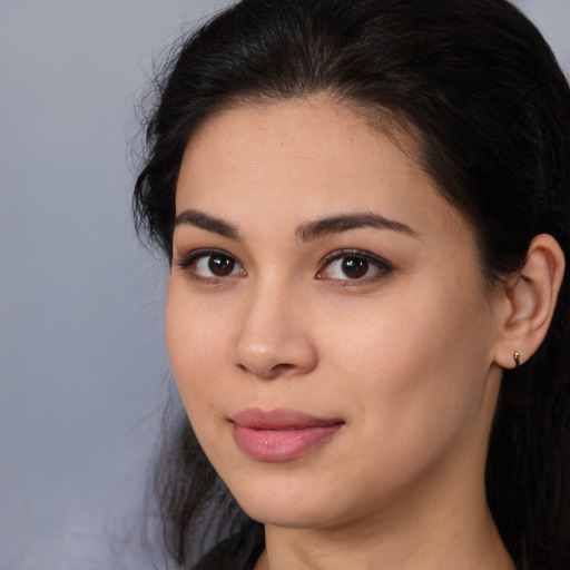 Joyful latino young-adult female with long  brown hair and brown eyes