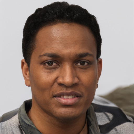 Joyful black young-adult male with short  black hair and brown eyes