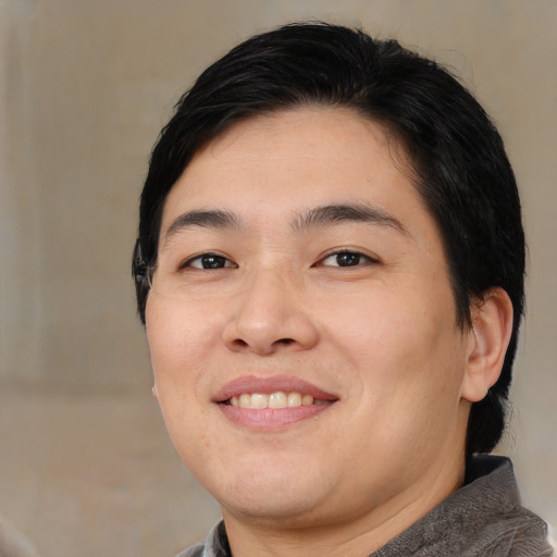Joyful asian young-adult male with medium  brown hair and brown eyes