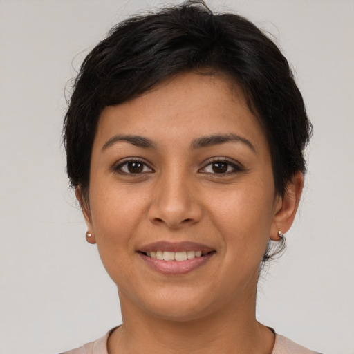 Joyful latino young-adult female with short  brown hair and brown eyes