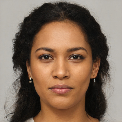 Joyful latino young-adult female with long  brown hair and brown eyes