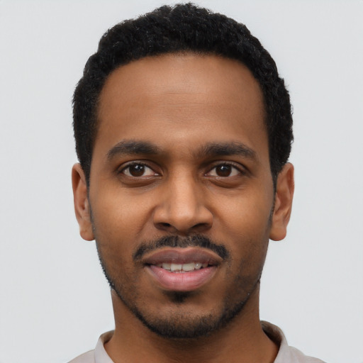 Joyful black young-adult male with short  black hair and brown eyes