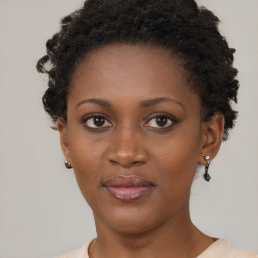 Joyful black young-adult female with short  brown hair and brown eyes