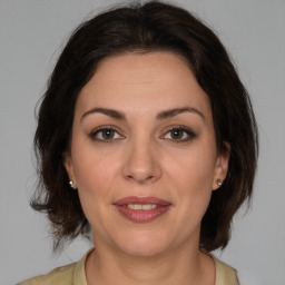 Joyful white adult female with medium  brown hair and brown eyes