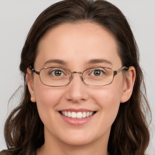 Joyful white young-adult female with medium  brown hair and grey eyes