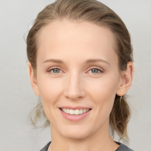 Joyful white young-adult female with medium  brown hair and blue eyes