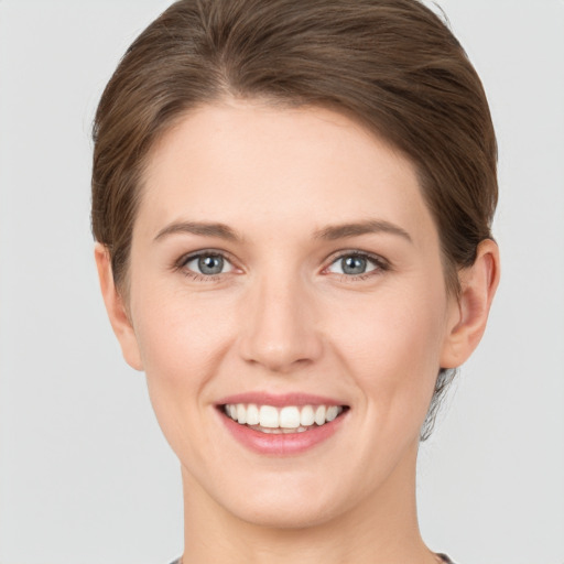 Joyful white young-adult female with short  brown hair and grey eyes