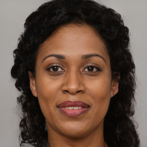 Joyful black adult female with long  brown hair and brown eyes