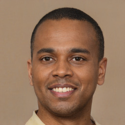 Joyful latino young-adult male with short  brown hair and brown eyes