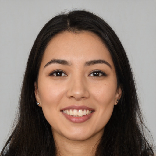 Joyful latino young-adult female with long  brown hair and brown eyes