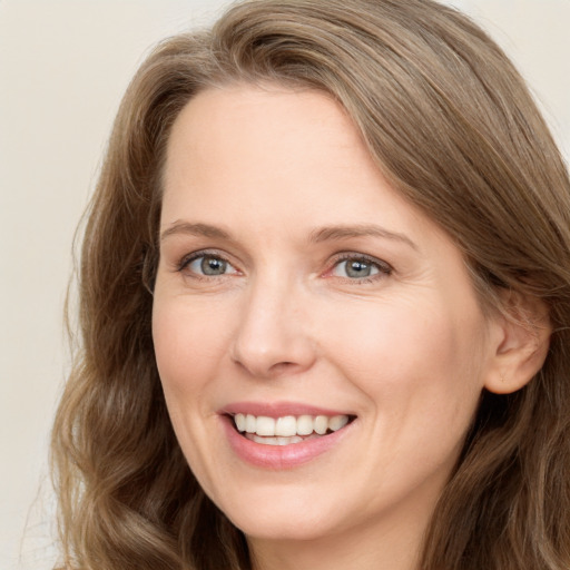 Joyful white adult female with long  brown hair and brown eyes