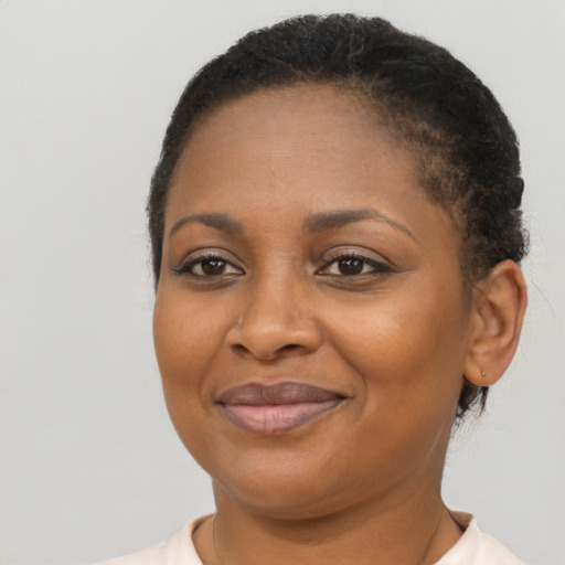 Joyful black adult female with short  brown hair and brown eyes