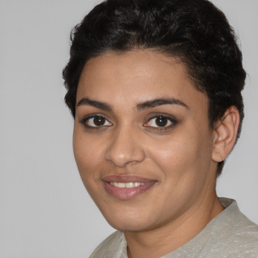 Joyful latino young-adult female with short  black hair and brown eyes