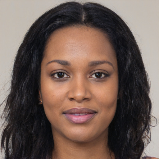 Joyful black young-adult female with long  black hair and brown eyes