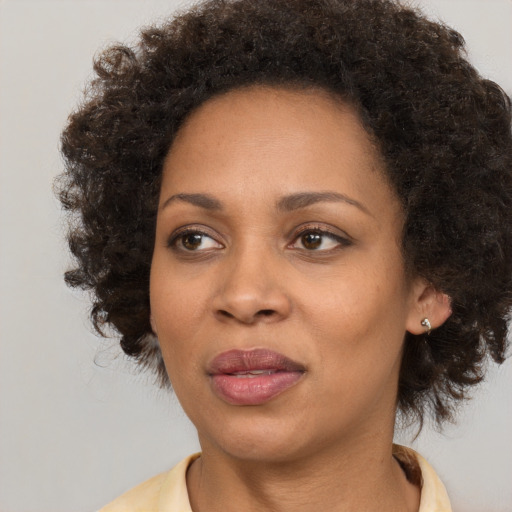 Joyful black adult female with medium  brown hair and brown eyes