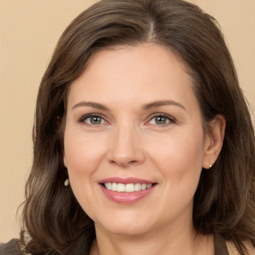 Joyful white adult female with long  brown hair and brown eyes