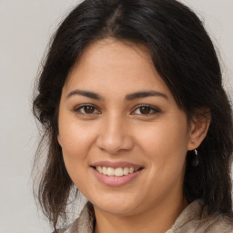 Joyful latino young-adult female with long  brown hair and brown eyes