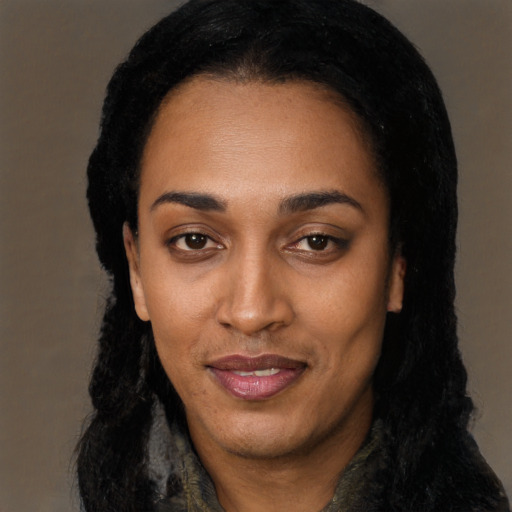 Joyful black young-adult female with long  black hair and brown eyes