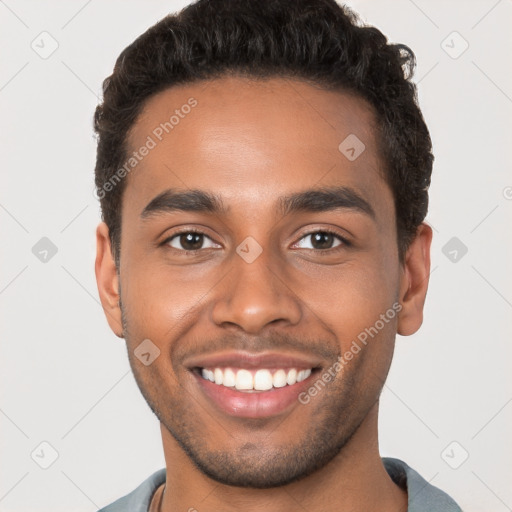 Joyful black young-adult male with short  brown hair and brown eyes