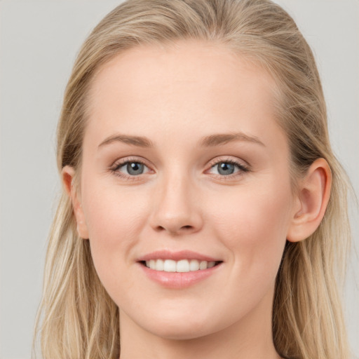 Joyful white young-adult female with long  brown hair and blue eyes