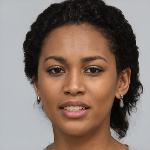 Joyful black young-adult female with long  black hair and brown eyes