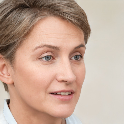 Joyful white adult female with short  brown hair and grey eyes