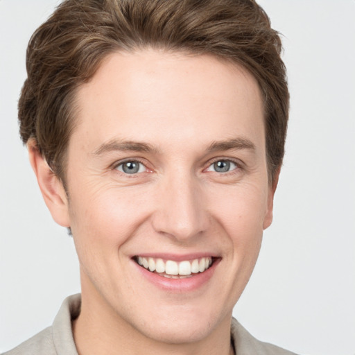 Joyful white young-adult male with short  brown hair and grey eyes