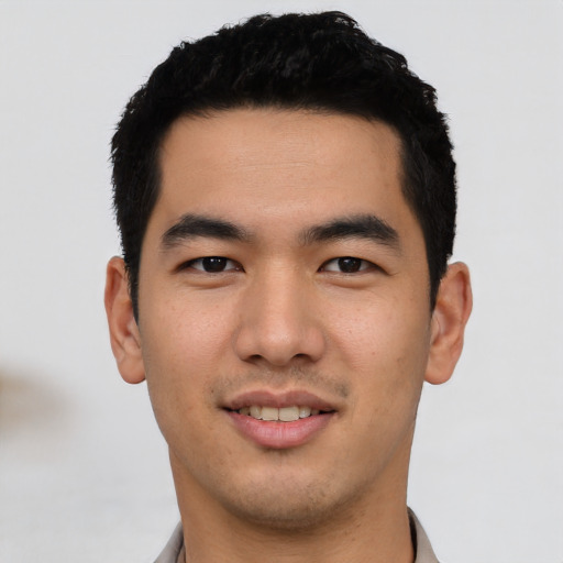 Joyful asian young-adult male with short  black hair and brown eyes