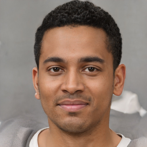 Joyful black young-adult male with short  black hair and brown eyes