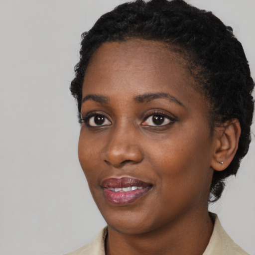 Joyful black young-adult female with short  black hair and brown eyes