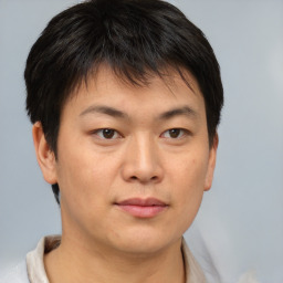 Joyful asian young-adult male with short  brown hair and brown eyes