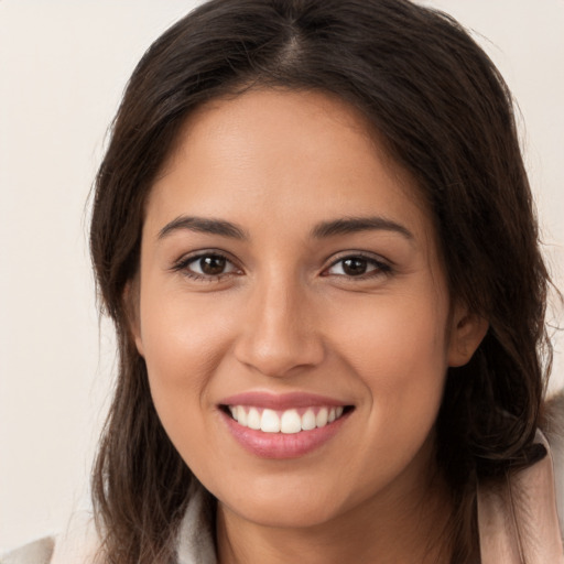 Joyful white young-adult female with long  brown hair and brown eyes